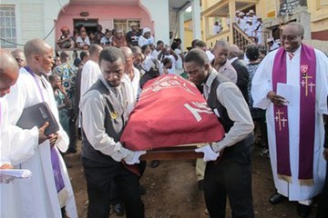 The body of 107-year-old Rev. Isaac Momoh Ndanema is led out of church for burial. Often called "Pa Ndanema," he chose to live simply and served as a peacemaker and social evangelist while encouraging the local language.Phileas Jusu, United Methodist Communications.