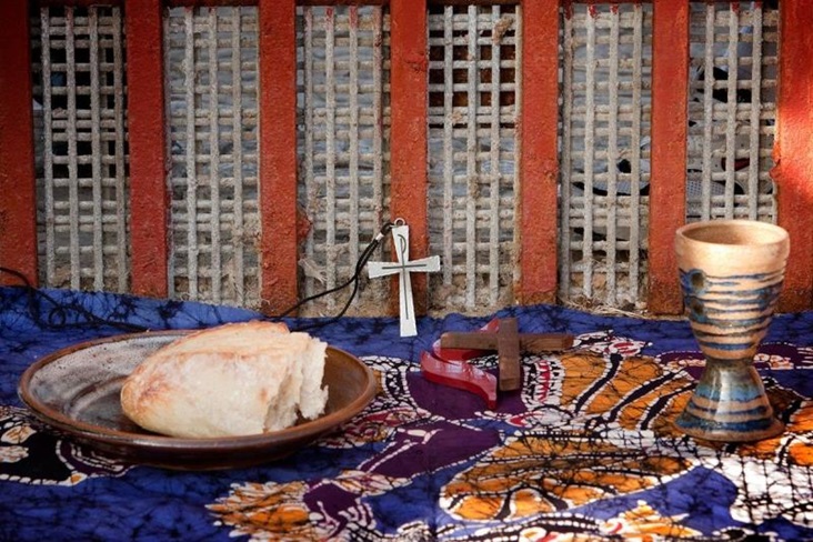The elements of Holy Communion are laid out against the Mexico side of the border fence between Tijuana and San Diego during a cross-border service at El Faro park in Tijuana, Mexico. Photo by Mike DuBose, UMNS