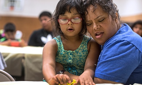 Danielle Lopez receives a hug from daughter Denise following the singing of Amazing Grace in Cherokee, North Carolina.