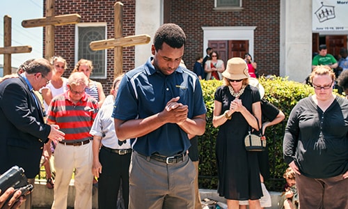 Robert Griggs (center) prays with others outside Morris Brown African Methodist Episcopal Church in Charleston, S.C. United Methodists joined AME members in prayers following the deadly shooting at Emanuel AME Church in Charleston. 