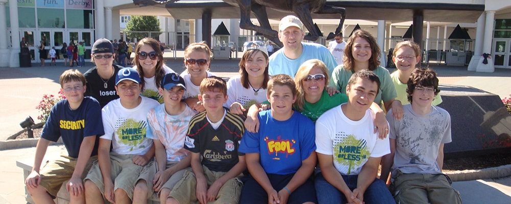 Group of students and counselor sitting on water fountain.