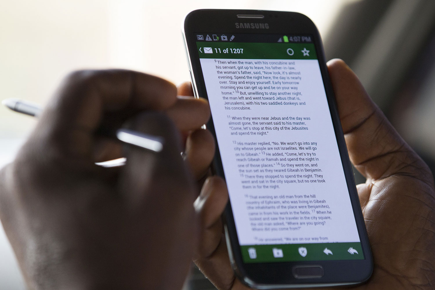 United Methodist Communicator Phileas Jusu reads a Bible verse on his mobile device in Freetown, Sierra Leone. Photo by Mike DuBose, UMNS.