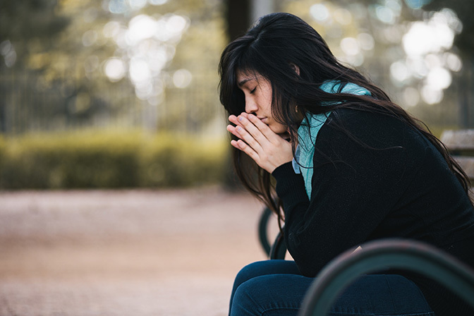 Woman praying alone. Image via Discipleship Ministries.