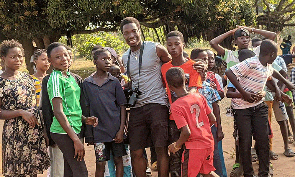 (Center) Mike Ayensu-Mensahis with some school children from school. Courtesy Photo.