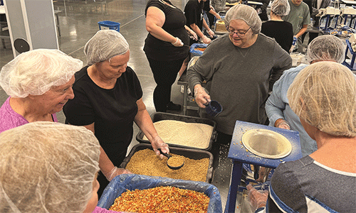 Members of our saviours and our redeemers packing food bags at feed our starving children.