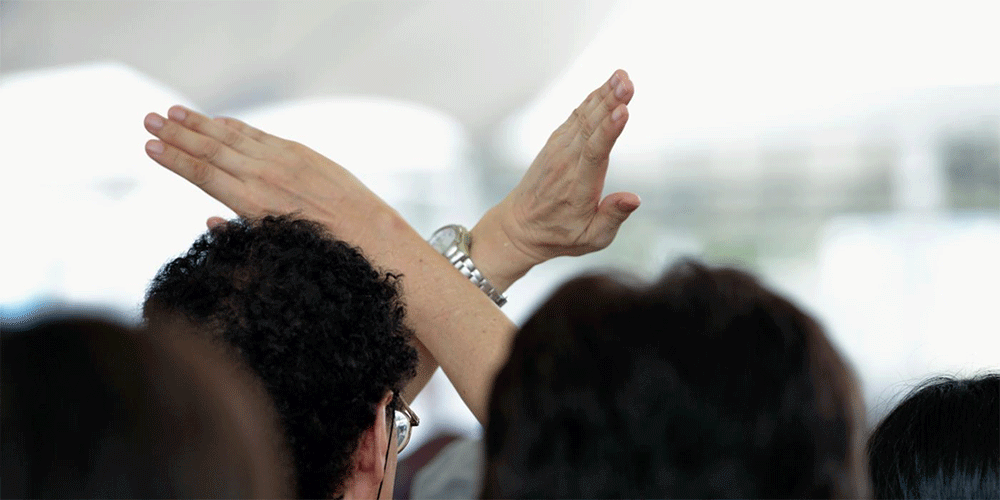 During a memorial ceremony in Nagasaki, Japan, on August 9, 2015, the 70th anniversary of the day the United States dropped an atomic bomb on the city, a man crosses his arms as a sign of protest during a speech by Prime Minister Shinzo Abe, Photo: Paul Jeffrey/Life on Earth Pictures.