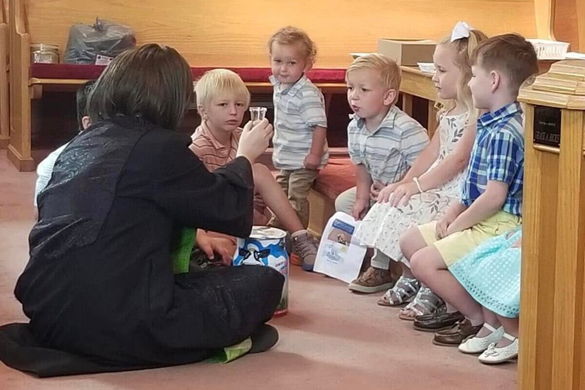 La Rev. Natalie Justice (izquierda) continuó sirviendo en sus dos cargos pastorales durante su segunda batalla con el cáncer. Nos dice: “mi doctor y enfermeras se sorprendieron mucho, pero lo dejamos en manos de Dios”. En esta foto, Justice dirige la adoración con una peluca puesta. Foto cortesía de Justice.
