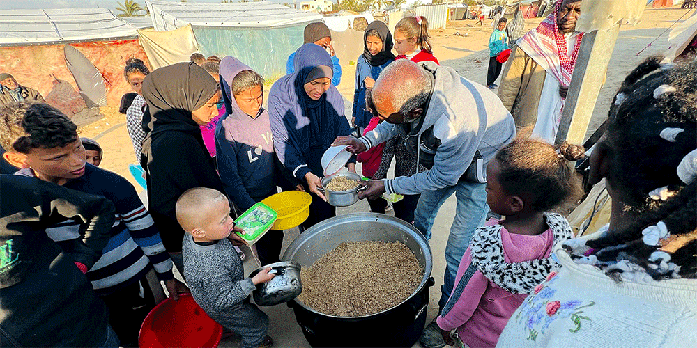 Hana's* family arrives at the camp gathering point for a hot, cooked meal. (Photo: IOCC) *names have been change