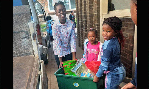 Maitaishe Gwara (from left) and Mecala and Chipiwa Zhungu carry their gifts to a vehicle for transportation to the local hospital in Harare, Zimbabwe. Members of the Harare Inner-City United Methodist Church junior Sunday school program raised $2,500 to provide gifts for children in the pediatric ward. Photo by Chenayi Kumuterera, UM News.